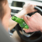 Man drinking beer while driving in his car