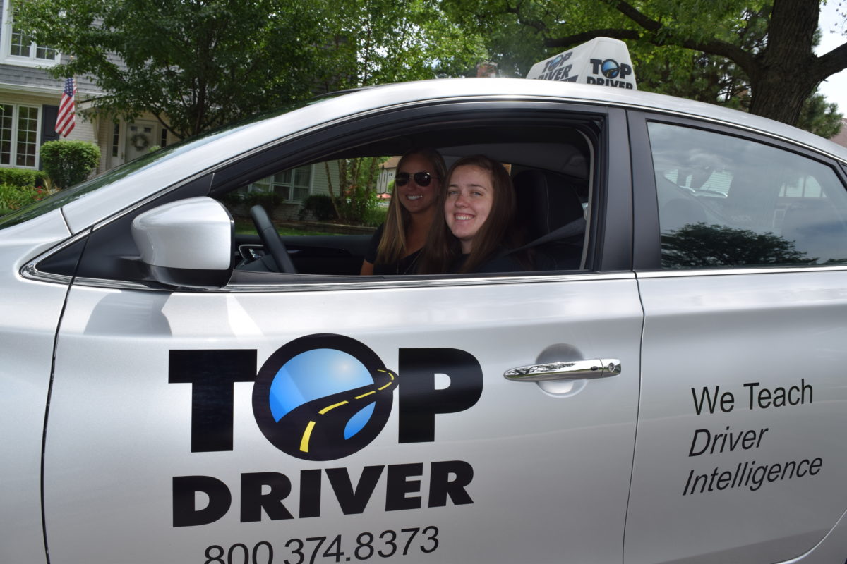 Fun with drivers ed. Teen in car with driving instructor.